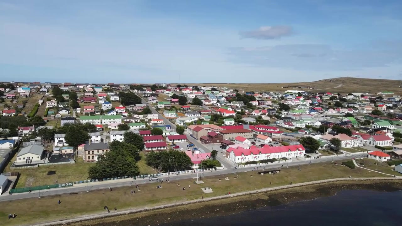 Drohnenflug über die Stadt Port Stanley auf den Falklandinseln, die farbenfrohe Stadtansicht zeigend.