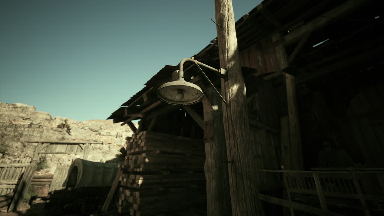 A rustic wooden barn with a vintage light and stacked timber at dusk