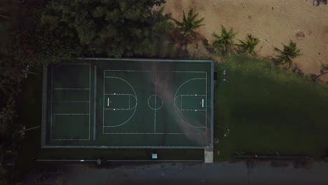 Drone-Shot-directly-above-an-empty,-green-basketball-court