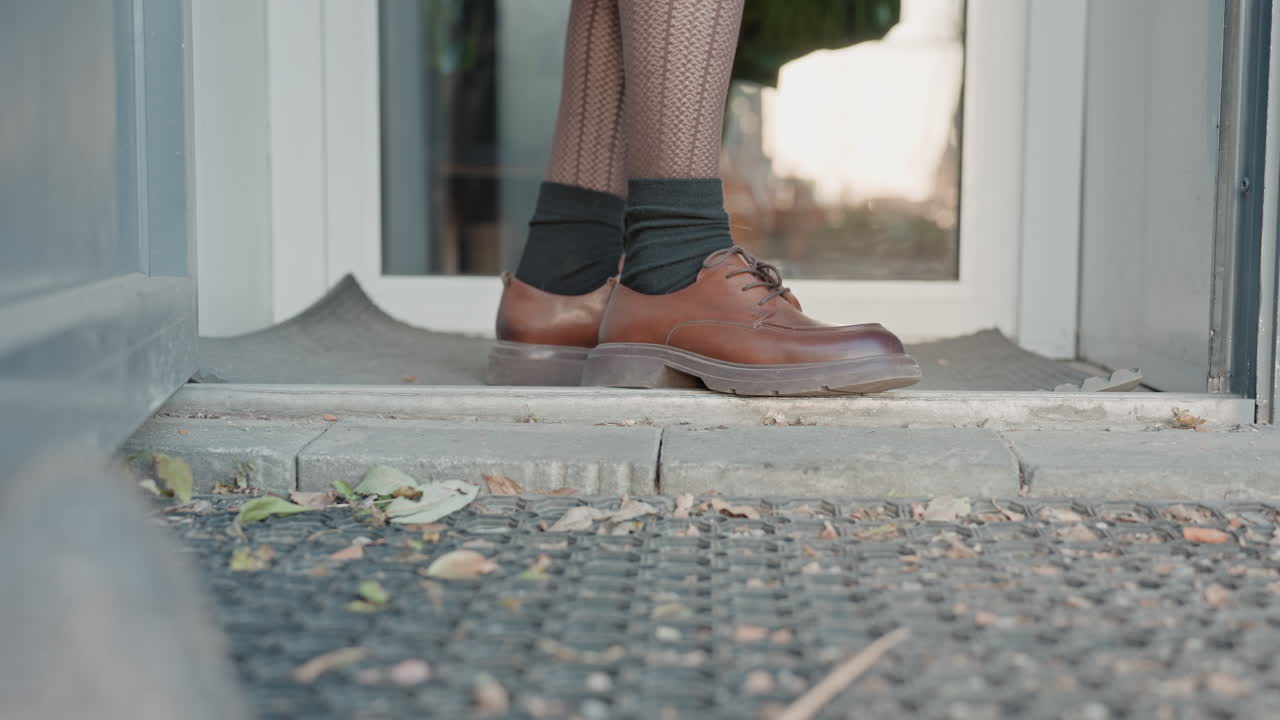 Caucasian lady steps inside store. Caucasian woman with patterned socks enters florist establishment through doorway. Woman with leather footwear and patterned socks walks into flower shop premises