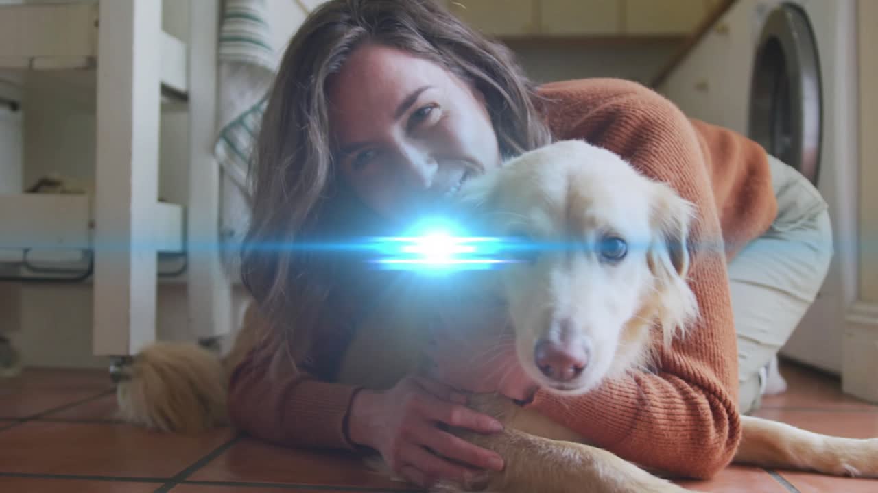 Dono de animal de estimação ajoelhado no chão, abraçando um cão de cor creme, com um brilho de lente em movimento e o cão se aproximando da câmera.