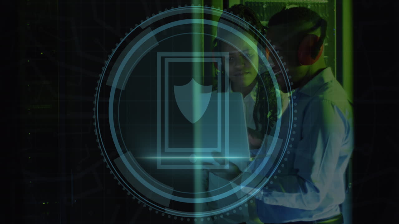 Animation of shield icon over african american male and female engineer using laptop at server room