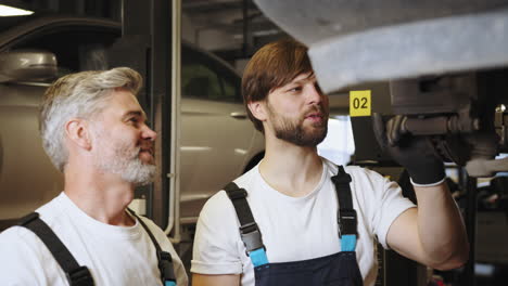 técnicos de reparación de automóviles inspeccionando el tren de aterrizaje