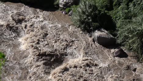 raging dirty water flowing through the valley