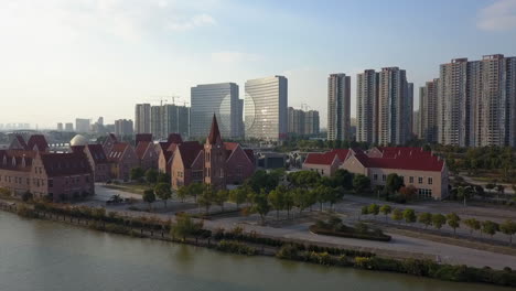 Clock-tower-on-river-waterfront-of-tall-modern-Suzhou-city-in-China