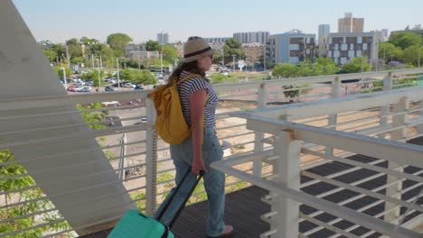 woman in summer hat walking through airport walkway