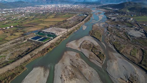 el agua contaminada del río fluye a través del cauce dañado entre el vertedero y las industrias mineras de arena