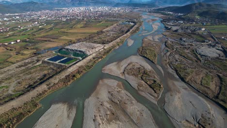 polluted water of river flows through damaged riverbed between the landfill and the sand mining industries