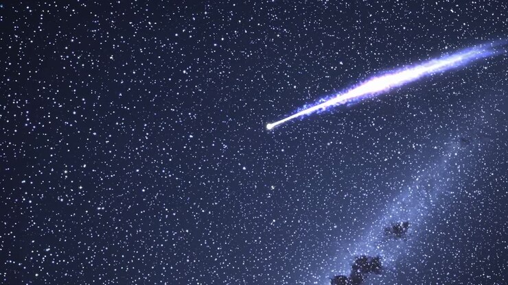 A mesmerizing video still of a shooting star streaking across a starry night sky