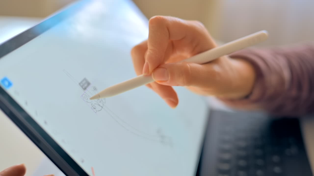 スタイラスペンを使ってグラフィックタブレットでスケッチをする女性