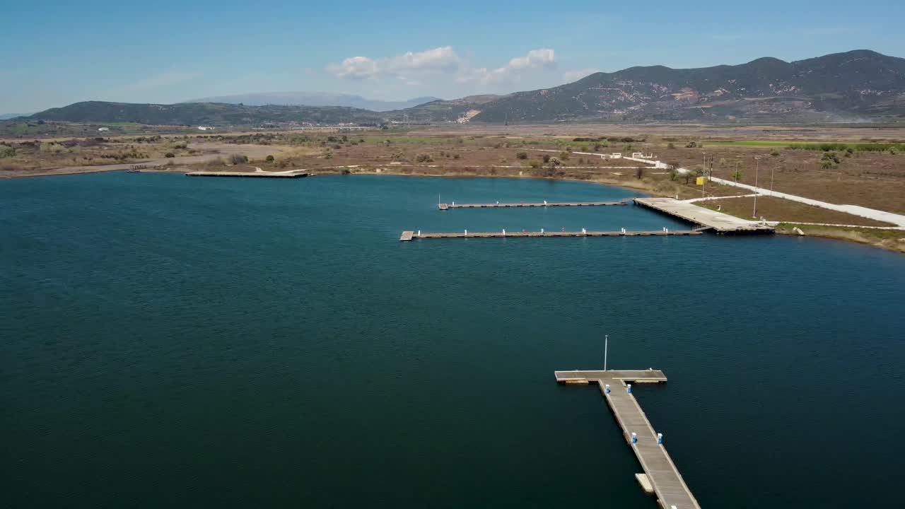 Aerial pan of abandoned port on lake in Greece