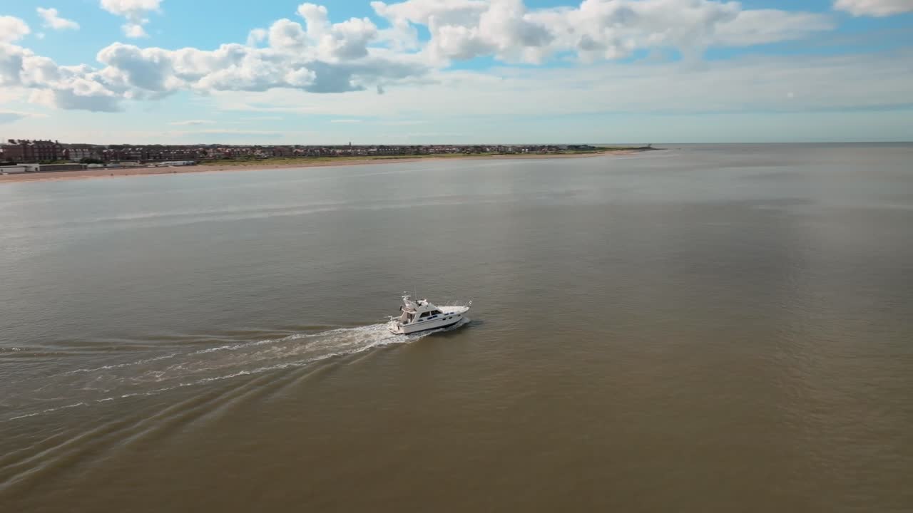 Motorboat On Calm Estuary Water With Camera Orbit Revealing Coastline On Sunny Day. Fleetwood, Lancashire, UK