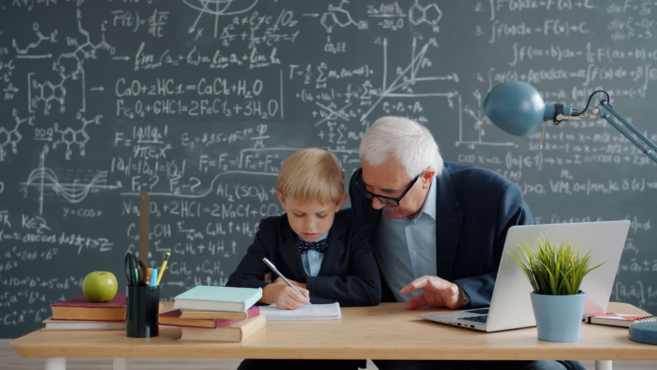 Grandfather Tutoring Grandson in Classroom