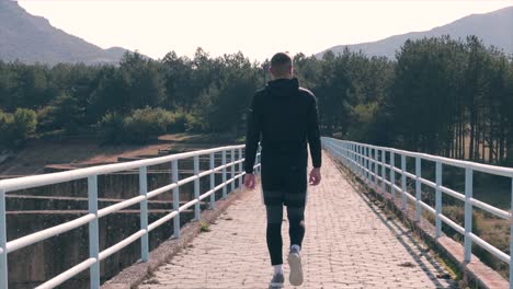 man walking on a dam sightseeing the beautiful nature