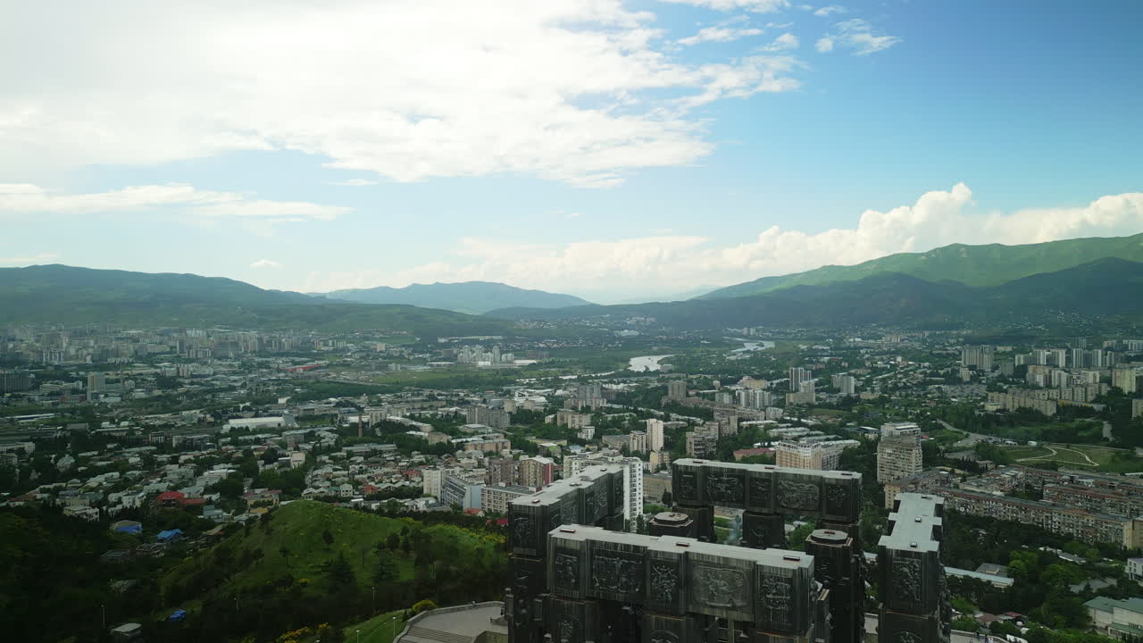 Panoramic Aerial View of Tbilisi, Georgia, Featuring the Chronicle of Georgia Monument and Surrounding Mountains