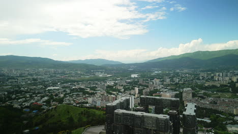 panoramic aerial view of tbilisi, georgia, featuring the chronicle of georgia monument and surrounding mountains