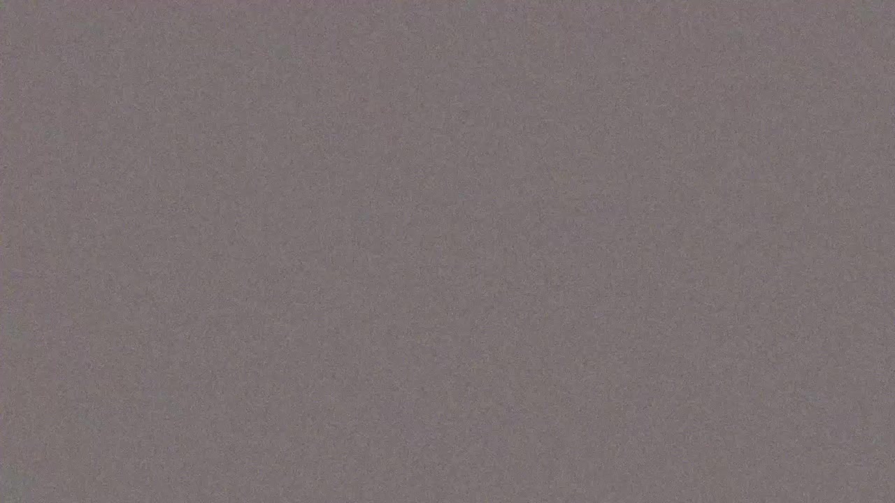 Neutral grey analog film grain overlay with medium RGB color noise, seamless loop cinematic texture