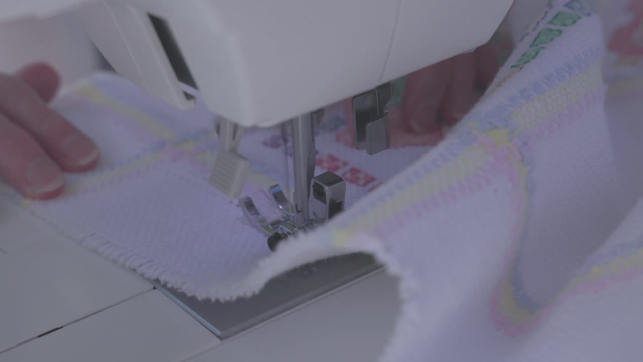 sewing machine quickly creating a stitched border around a baby blanket