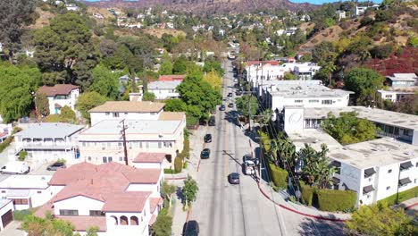 Aerial-Tilt-Up-Reveal-Beachwood-Drive-In-Hollywood-With-Cars-Driving-Up-Towards-Hollywood-Sign