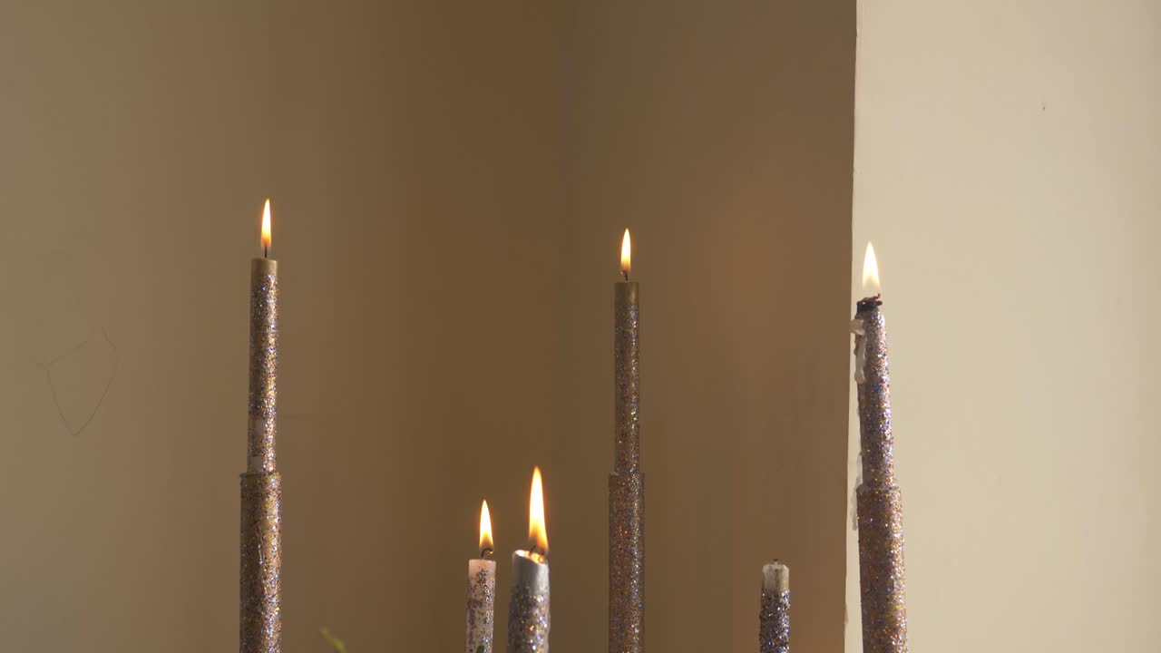 The candles is ready for a wedding day to be put in front of the groom while everyone is dancing in front of him