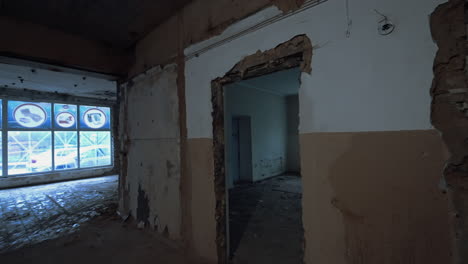 leaving the empty room painted white with two windows. two pushcarts are in the corridor for debris or construction materials transition.