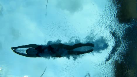 underwater slow motion shot of a swimmer diving into a swimming pool