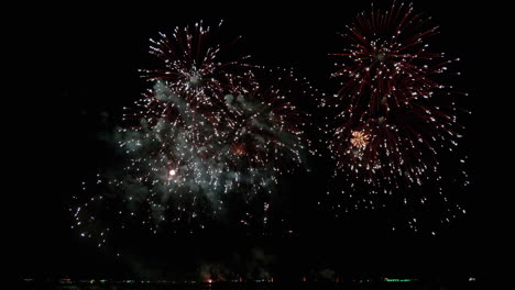 El-Lanzamiento-Sistemático-De-Fuegos-Artificiales-Desde-Altitudes-Bajas-A-Altas-Revela-El-Clímax-De-Una-Extraordinaria-Exhibición-De-Chispas-Y-Llamas-De-Colores-Con-Luces-Bokeh-En-El-Cielo-Nocturno.