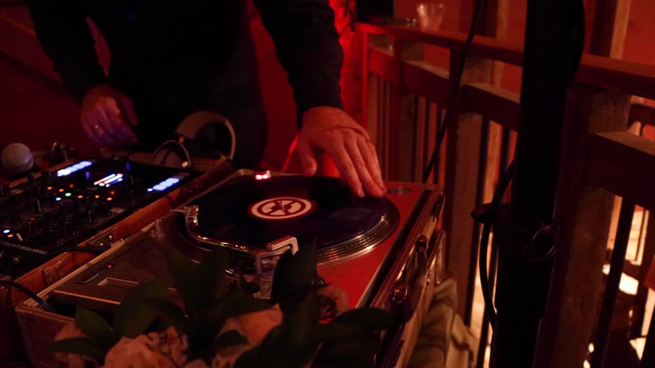 DJ scratching his turn tables at a luxury event.