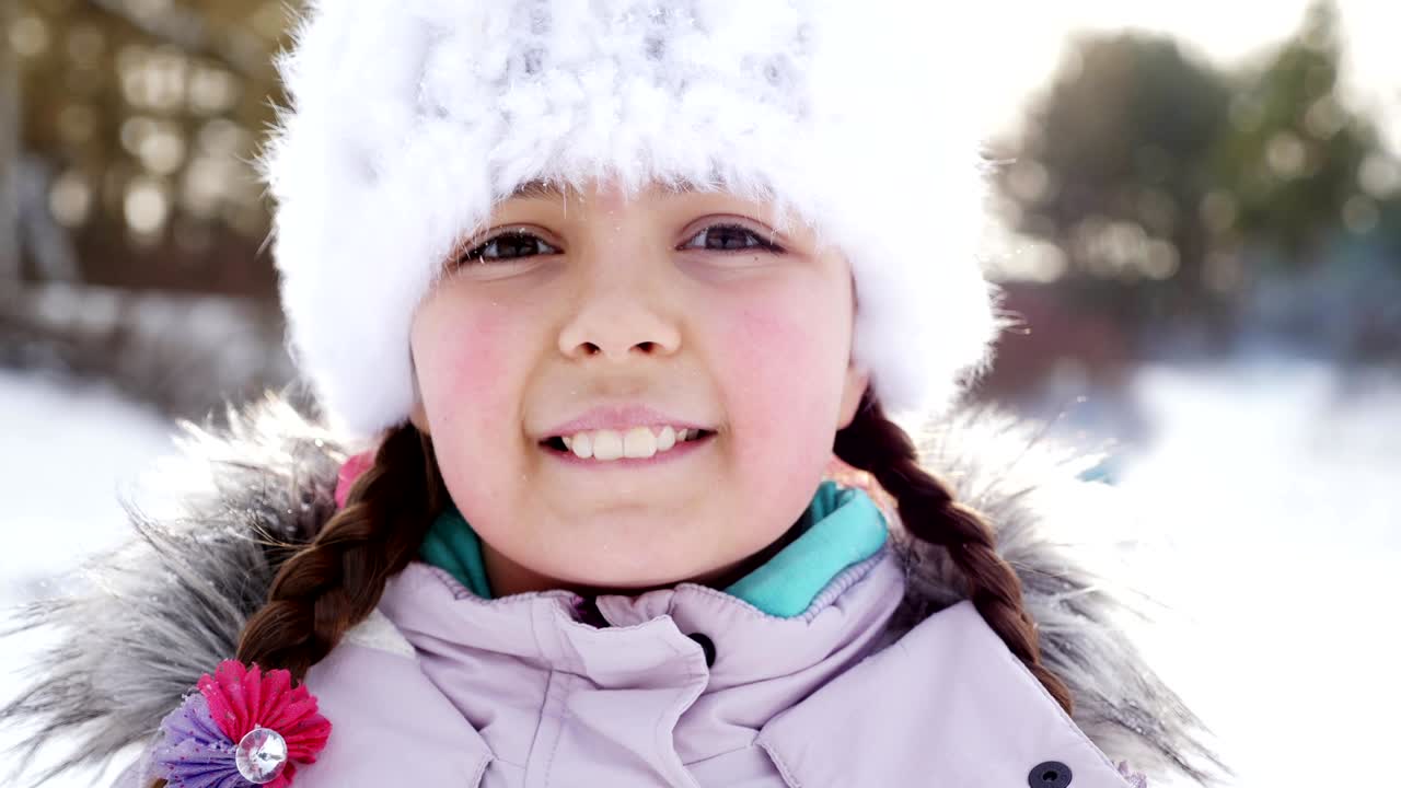 소녀는 눈을 던지는 것에 행복합니다. 클로즈업