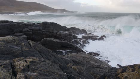 Toma-En-Cámara-Lenta-De-Grandes-Olas-Blancas-Rompiendo-Sobre-Un-Acantilado-Durante-Una-Tormenta-En-La-Bahía-Junto-A-La-Playa-De-Tangasdale,-Cerca-De-Castlebay-En-La-Isla-De-Barra