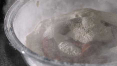 pretzel falling into bowl of flour