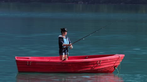 la mujer en el barco atrapa un pez en el giro en noruega.