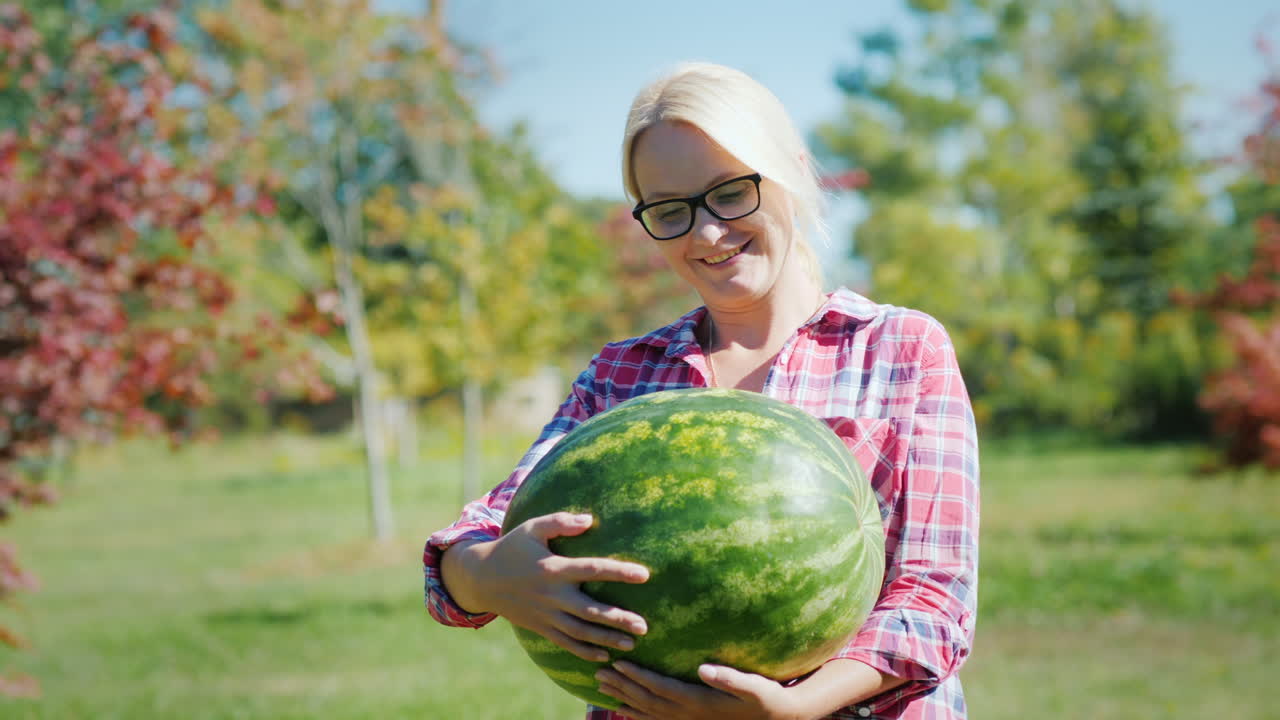 큰 수박을 가진 행복한 여자