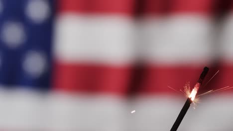 video of close up of sparkler with copy space over flag of usa