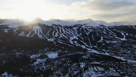 Aerial-Cinematic-drone-view-of-Breckenridge-Ski-area-and-town-from-Boreas-Pass-late-afternoon-sunset-over-mountain-tops-mid-winter-pan-forward-reveal-movement