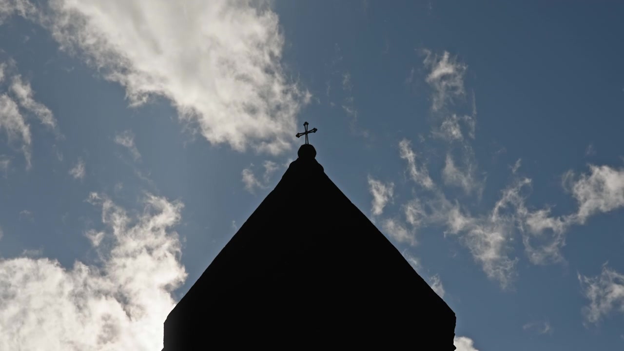 Časosběr mraků míjejících střechu kostela.