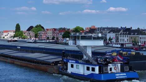 Large-ship-sailing-in-ocean-passing-by-buildings-and-homes