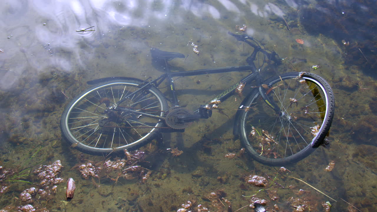 Panning shot of a abandoned bike in shallow water at Kristiansand harbour