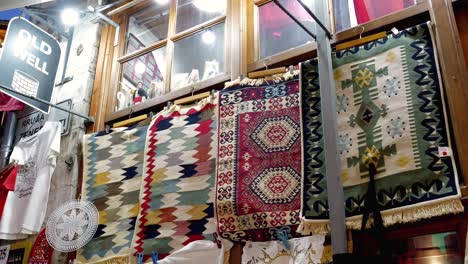 a souvenir stand in the albanian city of gjirokastër, featuring exquisite handmade carpets