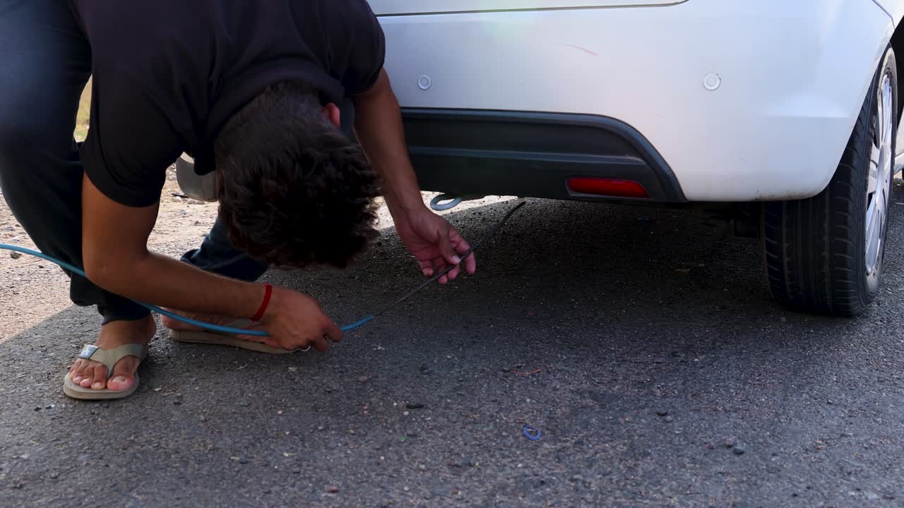 Man Repairing a Car on the Roadside