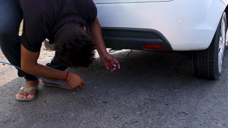 man repairing a car on the roadside