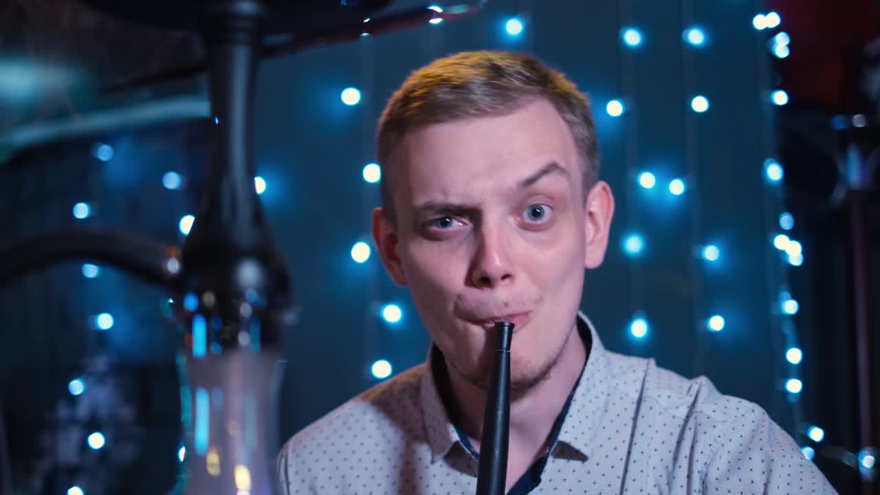 мужчина курит кальян.