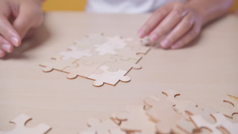 closeup hand of woman connecting jigsaw puzzle, business solutions, success and strategy concept