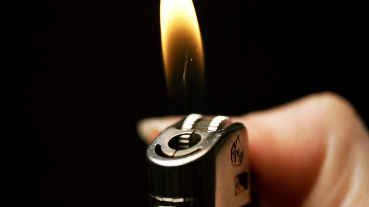 espectáculo encantador de chispas y llamas como una mano agita un encendedor en hipnotizante cámara lenta