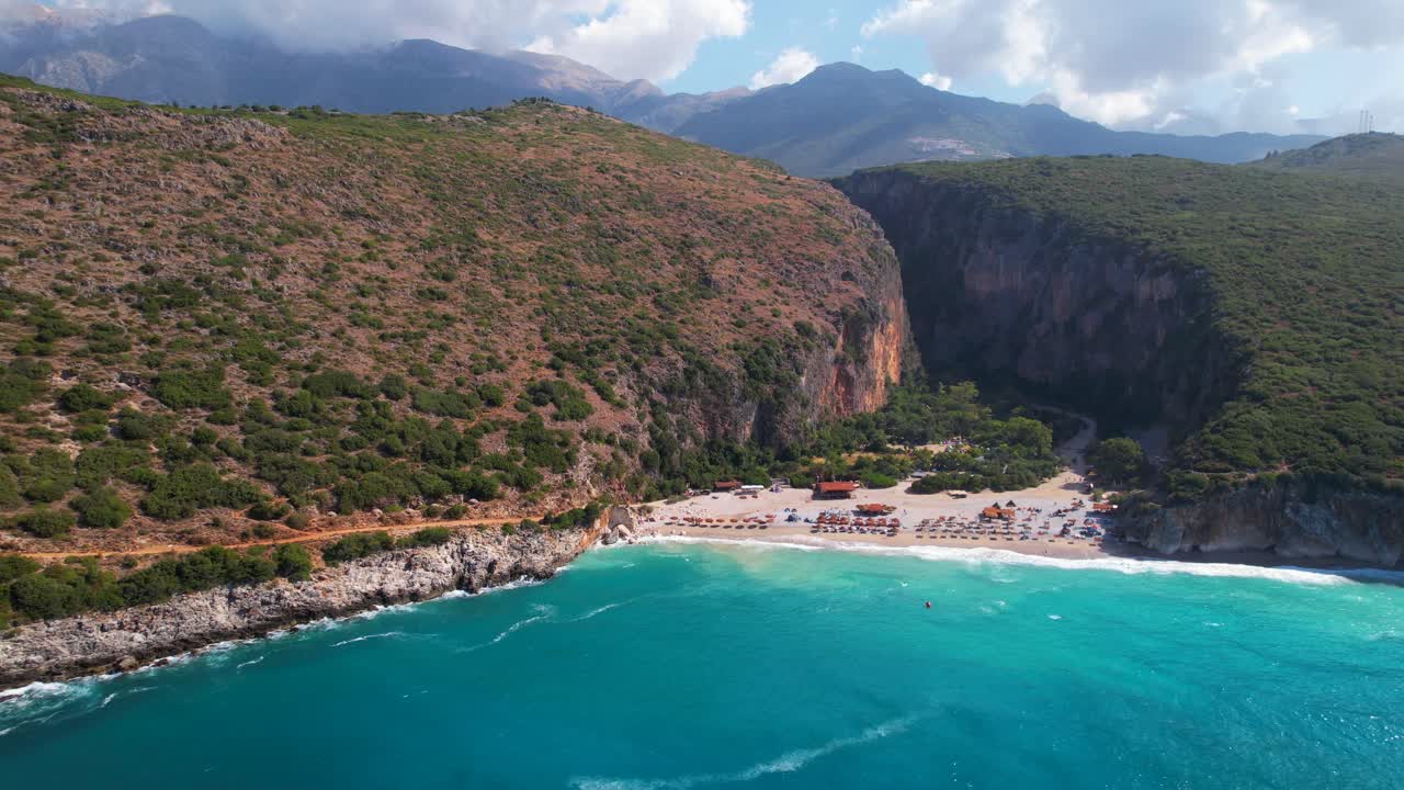 Remote beach of Gjipe in Albania, canyon filled with sand washed by sea waves of Mediterranean