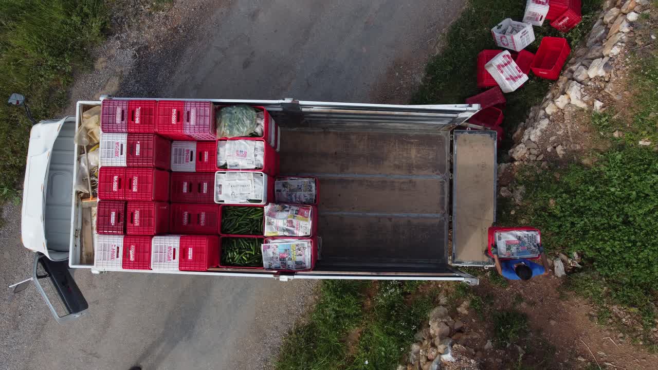 농업 노동자 들 이 상자 들 을 트럭 에 로드 하고 있다