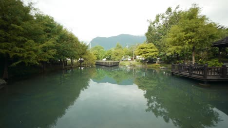 mountain and trees reflecting on pond with pagoda viewing area