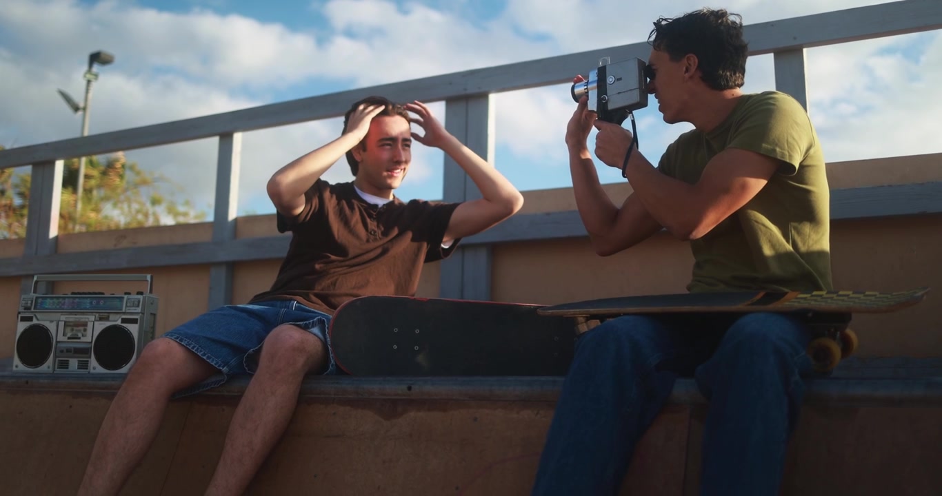 Young Men Filming Each Other with Vintage Camera at Skatepark