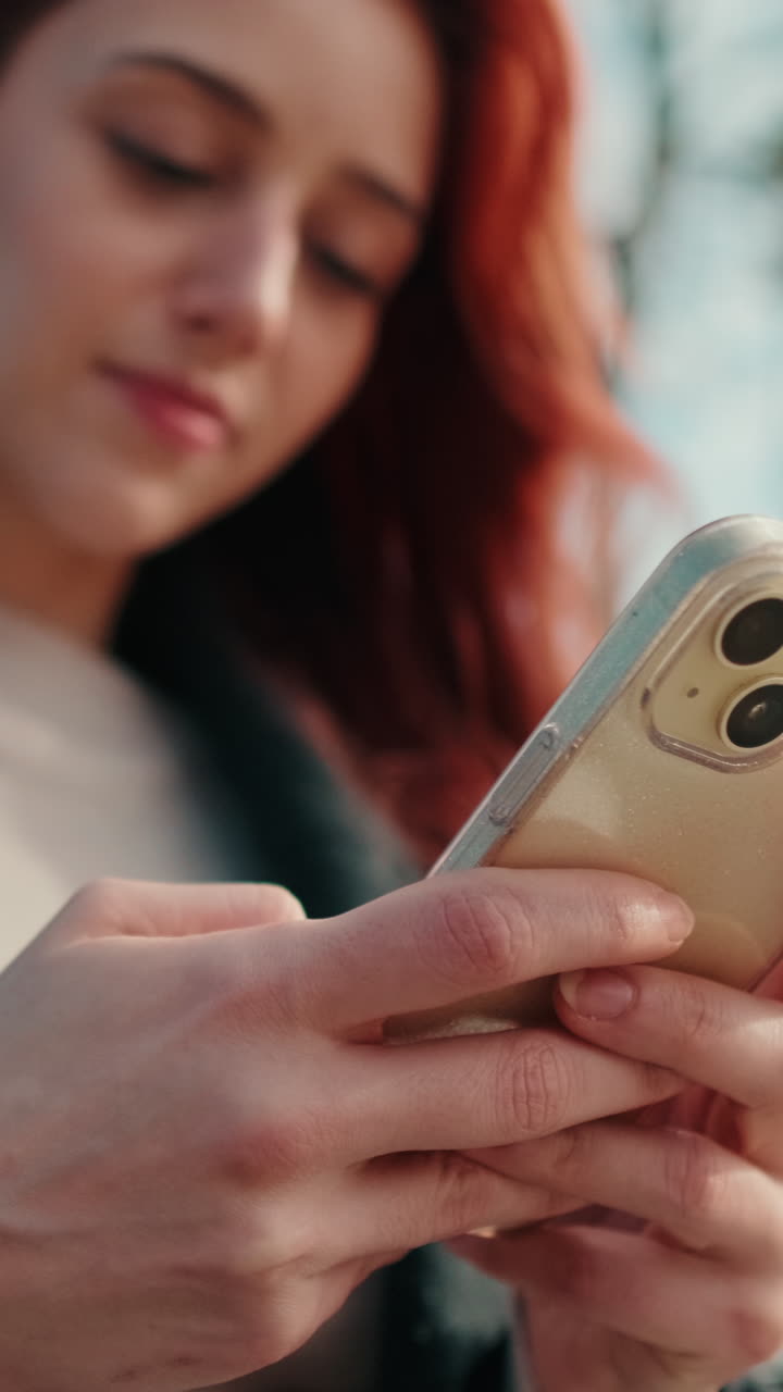 Primo piano di giovane donna che usa lo smartphone all'aperto