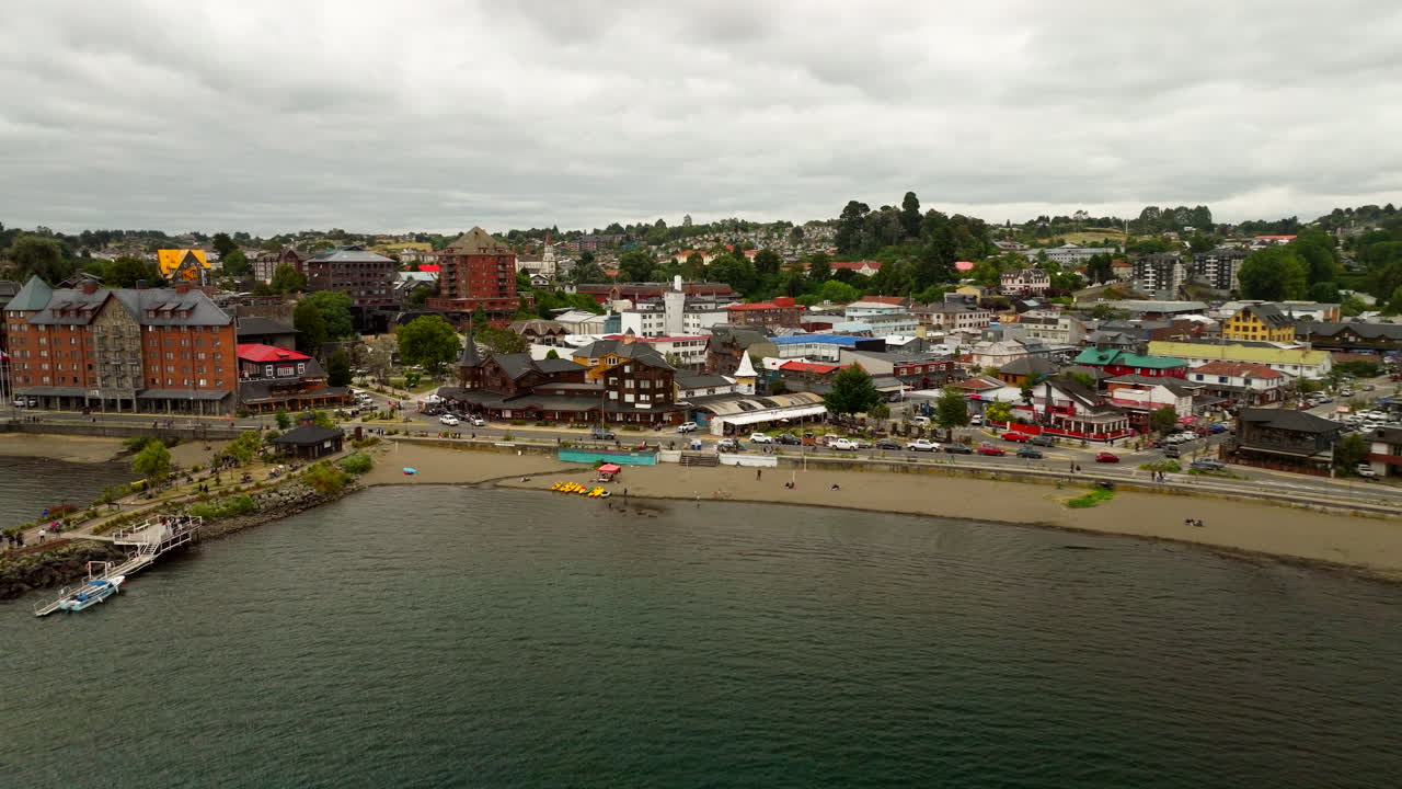 Picturesque town of Puerto Varas on shore of Lake Llanquihue, beach, pier, and German-influenced architecture, Patagonia, Chile. Aerial backward